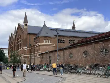 Oversigtsbillede af lang gade facade på gadefacaden, i tegl, natursten, mørtel og skifer.