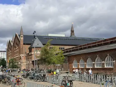 Oversigtsbillede af hoved station forplads facade set fra forpladsen, i tegl, natursten, mørtel og skifer.