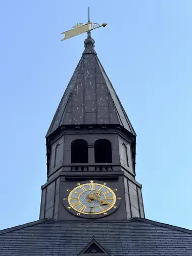 Billede af ur tårn spir udvendigt på bygningen, i skifer, metal, kobber og glas.