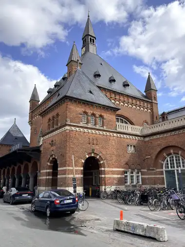 Oversigtsbillede af hoved indgang facade set fra forpladsen, i tegl, natursten, mørtel og skifer.